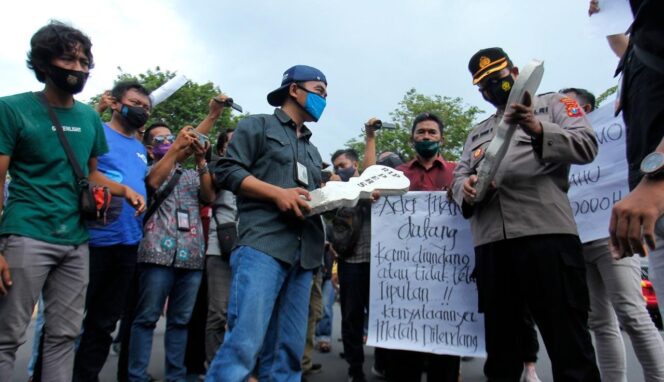 
					SOLIDARITAS: Perwakilan Pokja Jurnalis Kraksaan, Babul Arifandhie, saat menyerahkan batu nisan kepada polisi (foto: Ryan Khalig)