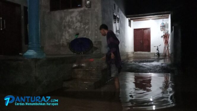 
					BANJIR: Salah seorang warga memantau banjir yang menerjang pemukimannya. 