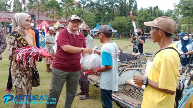 
					Hore! Penarik Bentor di Alun-alun Kraksaan Dapat Bendera dan Sembako Gratis 