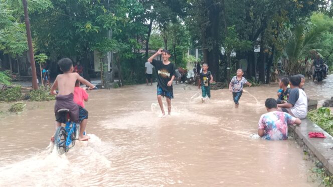 
					BANJIR: Sejumlah anak bermain di jalan Desa Rangkang Kraksaan yang terendam banjir. (foto: Ainul Jannah).