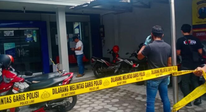 
					DIRAMPOK: Polisi memasang police line di depan Bank BRI Unit Kunir, Kab. Lumajang. (foto: Asmadi)