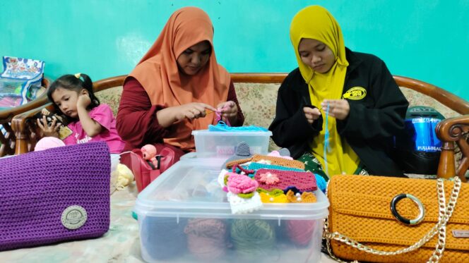 
					Kamelia (Kiri) bersama Siti Zulfana Dewi (kanan) menujukkan sejumlah produk hasil rajutannya.