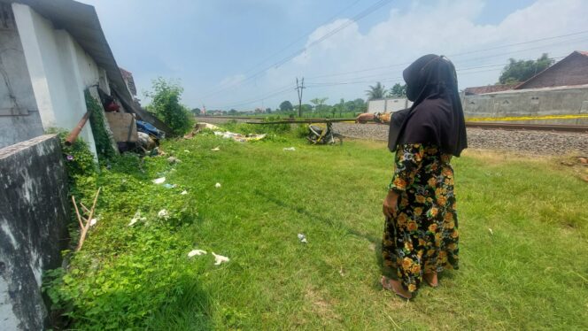 
					Asmida, pemilik warung dekat TKP menunjukkan lokasi penjaga perlintasan KA yang ditemukan tak bernyawa.