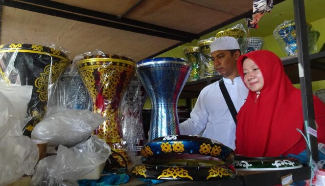 
					KREATIF: Pasangan suami istri, Akhmad Najidh dan Tutik Mudzakiroh, melihat produk darbuka buatan karyawannya. (foto: Moh. Rois)