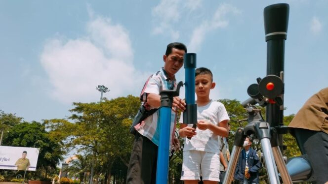 
					ANTUSIAS: Warga melihat fenomena gerhana matahari hibrida via teleskop di Alun-alun Bangil. (foto: Moh. Rois)