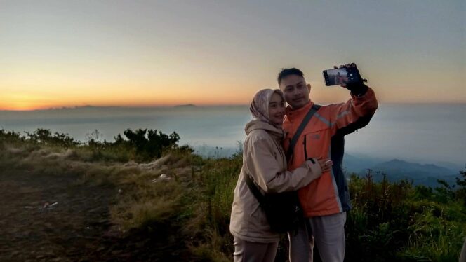 
					ROMANTIS: Pengantin baru, Agis dan Pinus, sedang berswafoto di Puncak B-29. (foto: Asmadi).