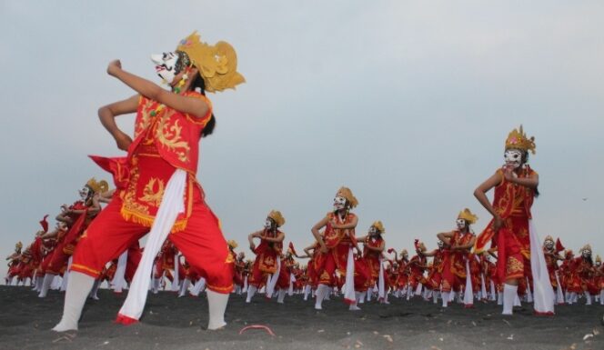 
					MERIAH: Tarian Topeng Kaliwungu oleh 500 penari tersaji rapi di Pantai Watu Pecak Lumajang. (foto: Asmadi)