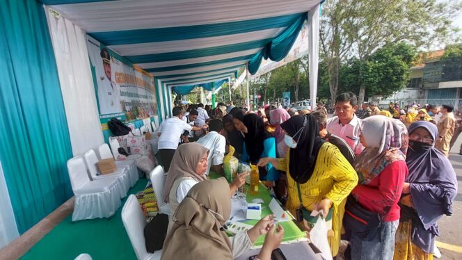 
					Warga menyerbu stand penjualan komoditas di pasar murah.