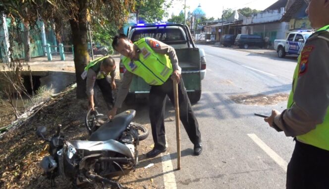 
					OLAH TKP: Petugas Unit Laka Lantas Polres Pasuruan memindahkan motor korban yang terlibat kecelakaan. (foto: Moh. Rois)