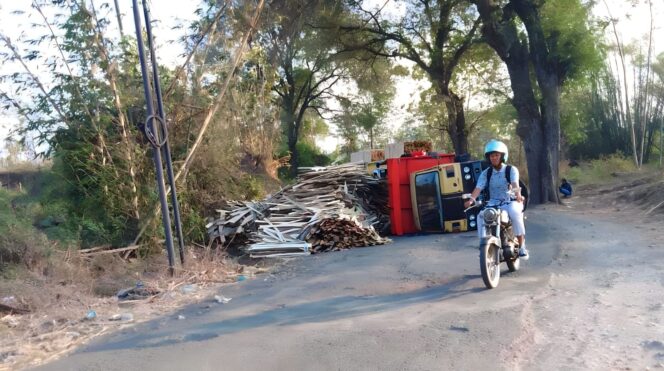 
					GULING: Truk bermuatan kayu terguling saat lintasi jalan rusak di jalan raya Tegalsiwalan, Probolinggo. (foto: Haliza)