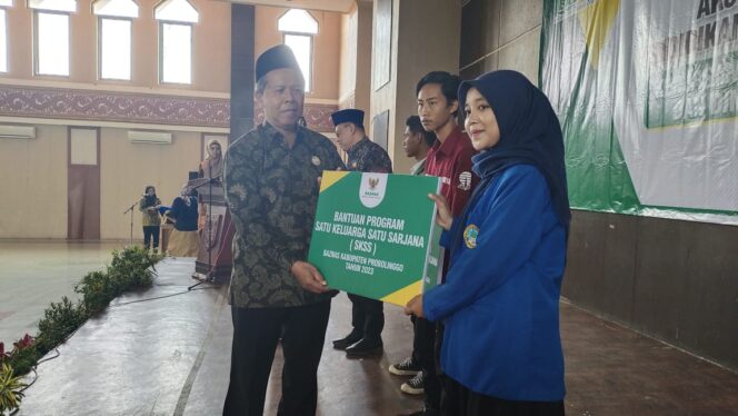 
					Muzammil secara simbolis memberikan bantuan beasiswa kuliah kepada salah seorang penerima.