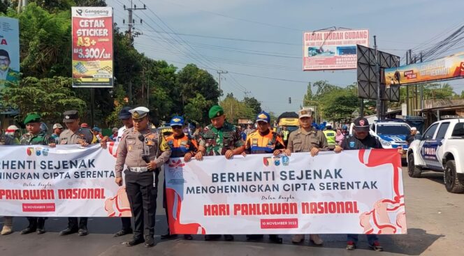 
					KHIDMAT: Petugas gabungan dan penggun jalan saat mengheningkan cipta di Simpang 3 Pajarakan. (foto: Ali Ya'lu)