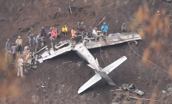 
					TERTANCAP: Petugas gabungan dan warga berusaha merelokasi pesawat TT-3111 yang tertutup tanah di tebing Lereng Bromo Pasuruan. (foto: Umarul Faruq).