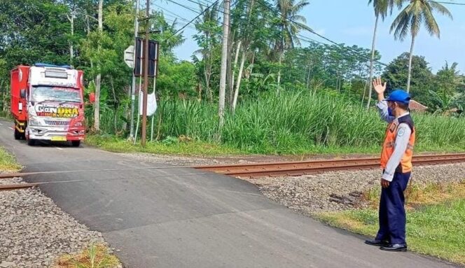 
					TITIK RAWAN: Seorang petugas Dishub Lumajang menjaga perlintasan tanpa palang pintu di wilayahnya. (foto: Asmadi)