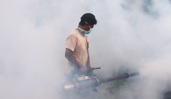 
					PERANGI DBD: Salah seorang petugas kesehatan sedang melakukan fogging untuk antisipasi penyebaran DBD di Kab. Lumajang. (foto: Asmadi).