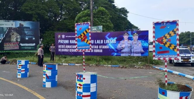 
					RAWAN LAKA: Anggota Satlantas Polres Pasuruan memasang rambu-rambu peringatan di kawasan jalur kecelakaan lalu lintas. (foto: Moh. Rois).