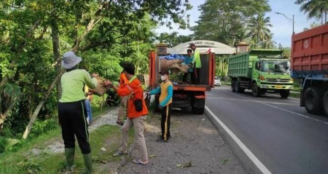 
					SAPU BERSIH: Petugas kebersihan di Lumajang saat membersihkan sampah di pinggir jalur nasional. (foto: Asmadi).