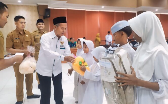 
					SANTUNAN: Ketua Baznas Kabupaten Probolinggo, H. Ahmad Muzammil saat memberikan santunan kepada anak yatim-piatu. (foto: Ali Ya'lu).