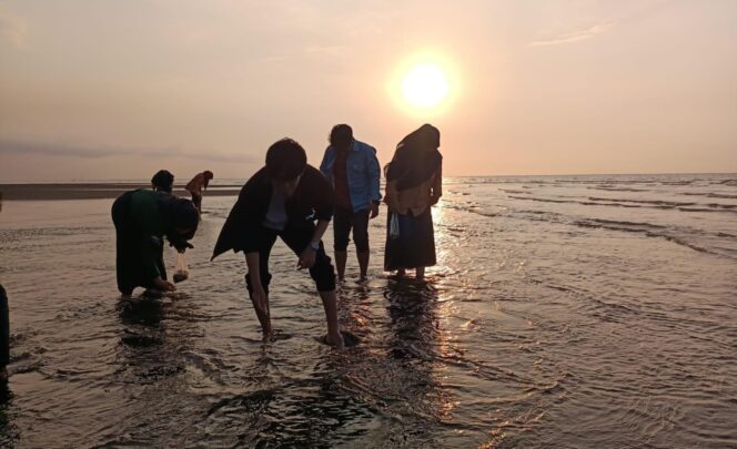 
					DESTINASI BARU: Sejumlah pengunjung sedang mencari kerang di Pantai Greenthing Paiton saat matahari mulai terbenam. (foto: Istimewa).