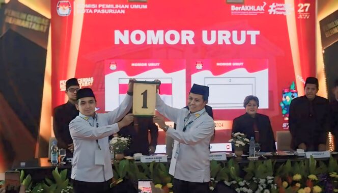 
					Pasangan calon Adi Wibowo dan Nawawi menunjukkan nomor urut 1 setelah pengundian nomor urut di KPU Kota Pasuruan. (Foto: Moh. Rois)
