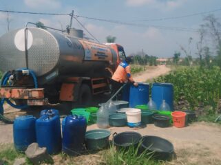 DROPING AIR: Petugas BPBD Kabupaten Probolinggo mengisi jeriken warga dengan air bersih. (istimewa)
