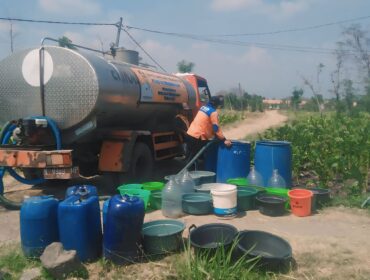 DROPING AIR: Petugas BPBD Kabupaten Probolinggo mengisi jeriken warga dengan air bersih. (istimewa)
