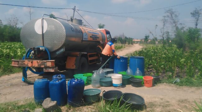 DROPING AIR: Petugas BPBD Kabupaten Probolinggo mengisi jeriken warga dengan air bersih. (istimewa)
