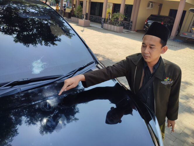 
					Santri Gus Mujib menunjukkan kaca mobil yang dilempar batu.