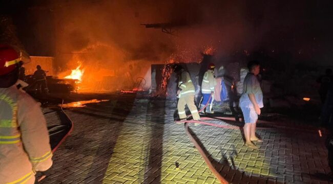 MEMBARA: Petugas Damkar Kota Probolinggo sedang memadamkan api yang melalap gudang gaharu di Mayangan. (foto: istimewa)