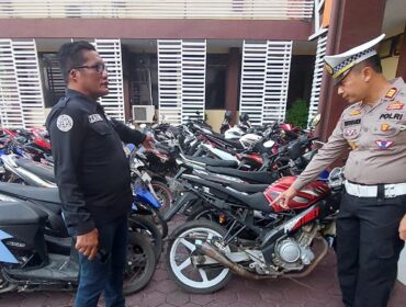 DIAMANKAN: Kasat Lantas dan Kasi Humas Polres Probolinggo Kota meninjau puluhan motor yang diamankan dari Jalan Semeru. (foto: Hafiz Rozani).