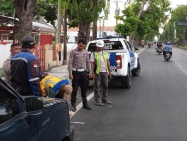 TINJAU: Petugas Satlantas Polres Probolinggo sedang meninjau lokasi yang akan dipasangi pita kejut di jalur pantura Kraksaan. (foto: Hafiz Rozani)