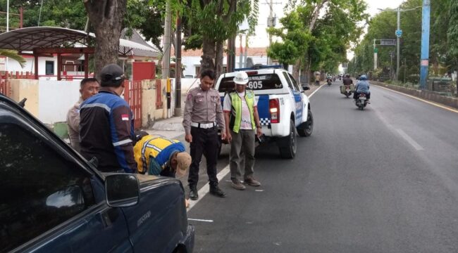 TINJAU: Petugas Satlantas Polres Probolinggo sedang meninjau lokasi yang akan dipasangi pita kejut di jalur pantura Kraksaan. (foto: Hafiz Rozani)