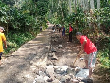 SWADAYA: Sejumlah warga sedang bergotong royong memperbaiki akses jalan perbatasan Kabupaten Probolinggo - Jember. (foto: Ali Ya'lu).
