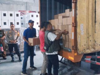 LOGISTIK: Petugas KPU menurunkan surat suara untuk Pilgub Jatim di Gudang KPU Kota Probolinggo. (foto: Hafiz Rozani).
