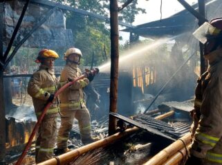 TERBAKAR: Petugas Damkar Kota Probolinggo melakukan pemadaman kandang sapi yang dilalap si jago merah. (foto: istimewa)