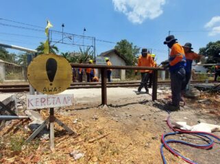 DITUTUP: Petugas KAI Daop 9 Jember memasang rel kereta api bekas untuk menutup permanen perlintasan liar di Desa Lemahkembar, Kecamatan Sumberasih, Kabupaten Probolinggo. (foto: Hafiz Rozani).
