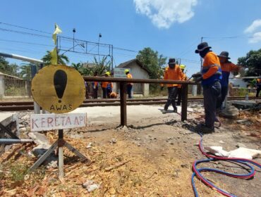 DITUTUP: Petugas KAI Daop 9 Jember memasang rel kereta api bekas untuk menutup permanen perlintasan liar di Desa Lemahkembar, Kecamatan Sumberasih, Kabupaten Probolinggo. (foto: Hafiz Rozani).
