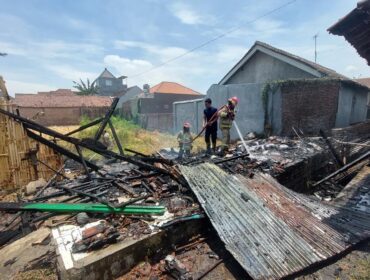 PEMADAMAN: Petugas Damkar Kota Probolinggo melakukan pemadaman rumah kontrakan yang terbakar. (foto: Hafiz Rozani).
