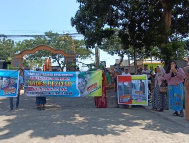 PROTES: Warga membawa spanduk saat demo di depan kantor Desa Dungun, Kecamatan Tongas, Kab. Probolinggo. (fofo: Hafiz Rozani)
