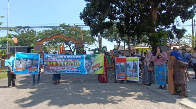 PROTES: Warga membawa spanduk saat demo di depan kantor Desa Dungun, Kecamatan Tongas, Kab. Probolinggo. (fofo: Hafiz Rozani)
