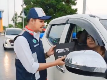 ANTISIPASI: Petugas Tol Paspro saat membagikan susu dan kopi ke pengendara di Exit Tol Probolinggo Timur. (foto: Hafiz Rozani).