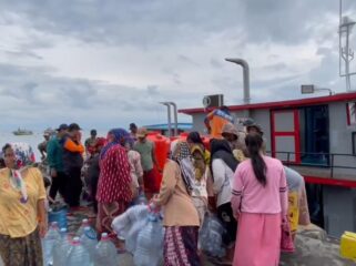 DROPING AIR: Petugas BPBD Kabupaten Probolinggo saat menyalurkan air bersih ke warga Pulau Gili. (foto: Hafiz Rozani).
