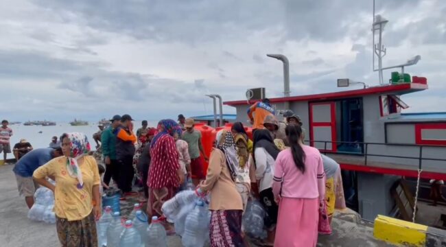 DROPING AIR: Petugas BPBD Kabupaten Probolinggo saat menyalurkan air bersih ke warga Pulau Gili. (foto: Hafiz Rozani).
