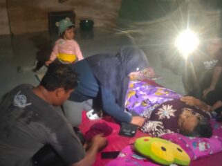 PINGSAN: Warga mengevakuasi lansia yang pingsan akibat rumahnya dilanda banjir. (foto: Moh. Rois)