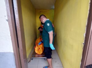 EVAKUASI: Petugas ambulans tengah mengevakuasi jenazah korban dari kamar kos ke kamar jenazah. (foto: Hafiz Rozani)
