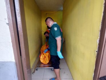 EVAKUASI: Petugas ambulans tengah mengevakuasi jenazah korban dari kamar kos ke kamar jenazah. (foto: Hafiz Rozani)
