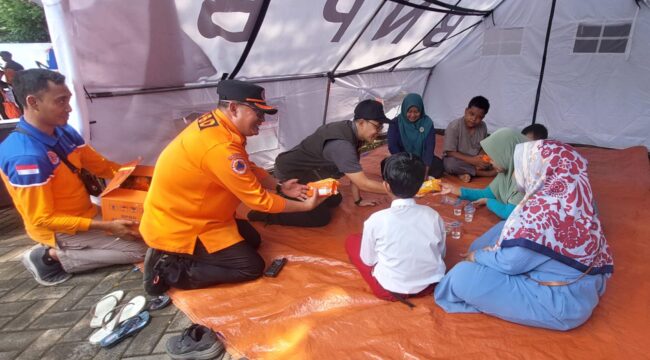 MITIGASI: Pj. Wali Kota Probolinggo, M. Taufik Kurniawan dan Kepala BPBD Kota Probolinggo, Sugito Prasetyo, bercengkrama dengan talent korban banjir saat simulasi bencana banjir. (foto: Hafiz Rozani).