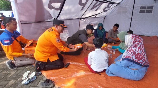 
					MITIGASI: Pj. Wali Kota Probolinggo, M. Taufik Kurniawan dan Kepala BPBD Kota Probolinggo, Sugito Prasetyo, bercengkrama dengan talent korban banjir saat simulasi bencana banjir. (foto: Hafiz Rozani).