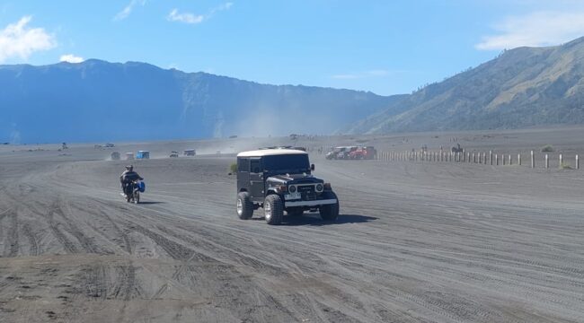 RAMAI: Sejumlah jip yang mengangkut wisatawan melintas di lautan pasir Bromo. (foto: Hafiz Rozani).