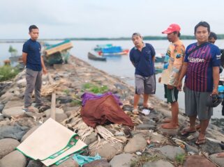 TEWAS: Warga dan petugas berada di dekat jenazah korban usai dievakuasi dari tengah laut. (foto: Hafiz Rozani).